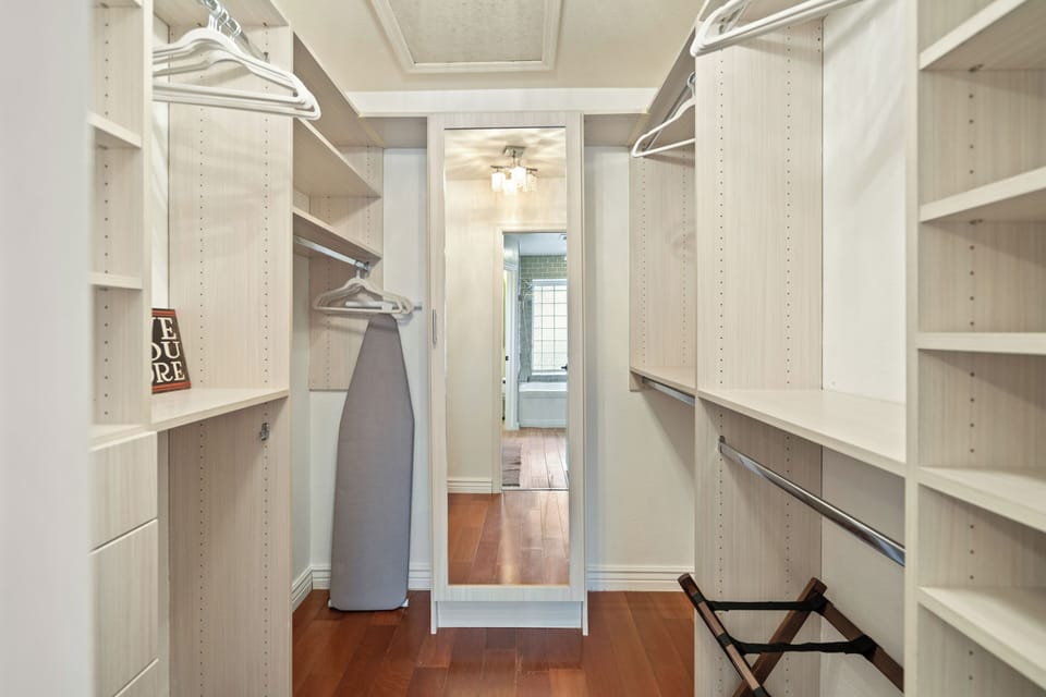 Spacious walk-in closet with full-length mirror, shelves & hangers