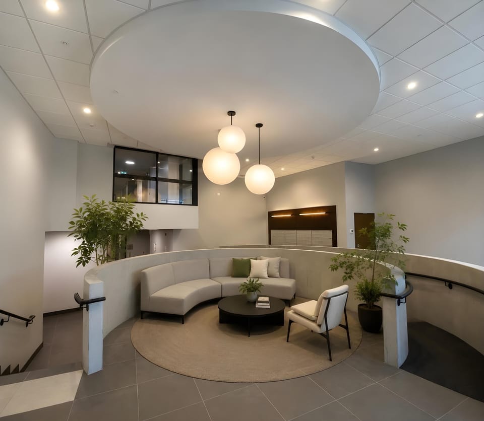 Stylish building lobby lounge featuring a curved accent seating area and architectural lighting.