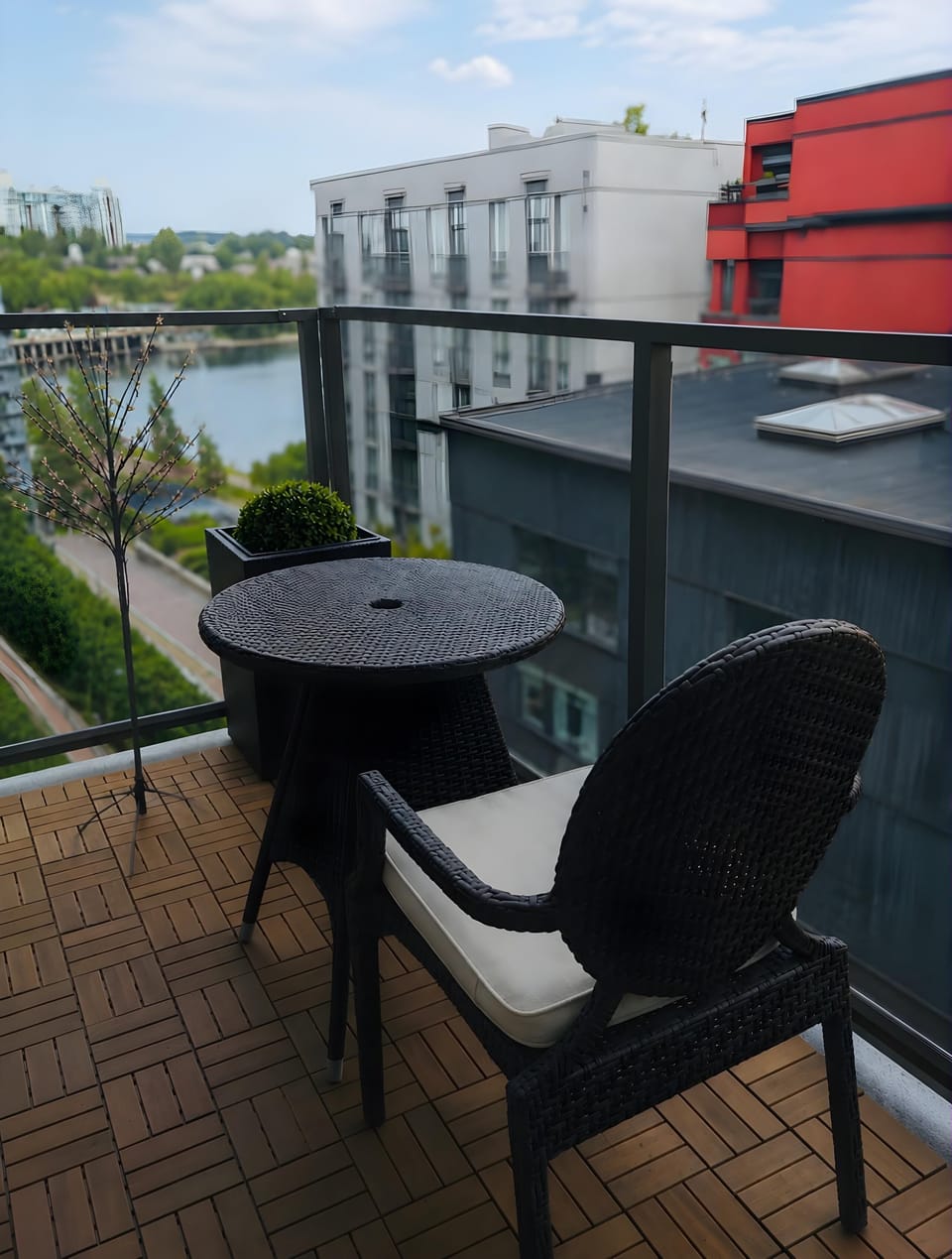 Private balcony space furnished with black wicker bistro seating—ideal for relaxing outdoors.