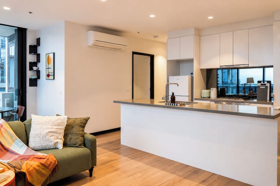 Bright open-plan living with sleek kitchen, breakfast bar, and cozy seating