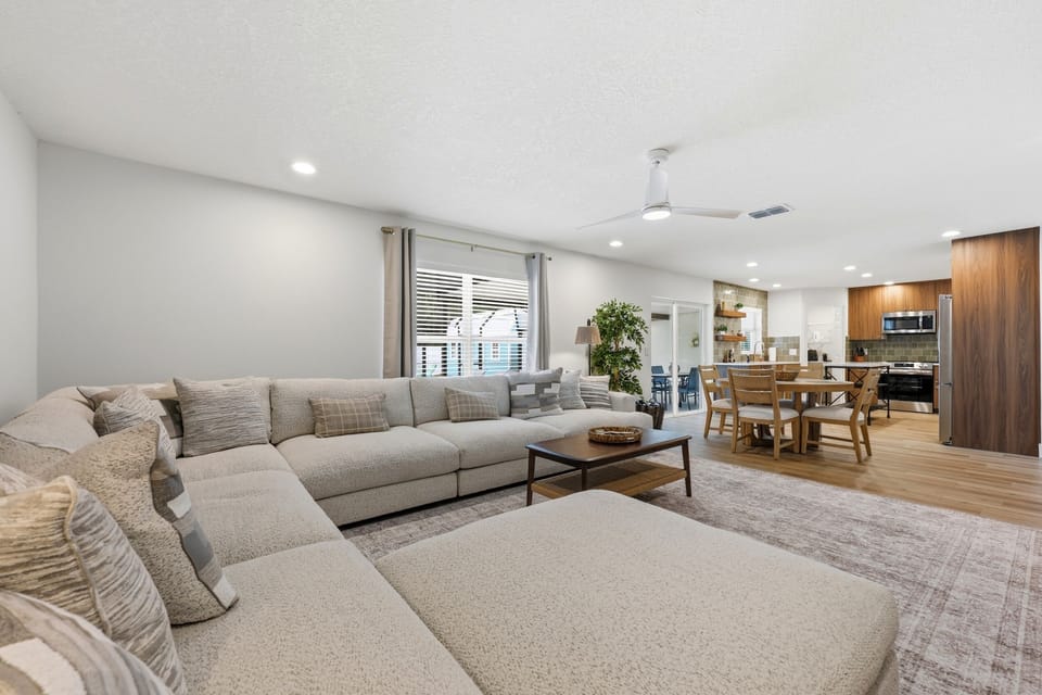 Open sightlines connect the living room, breakfast table, and kitchen.