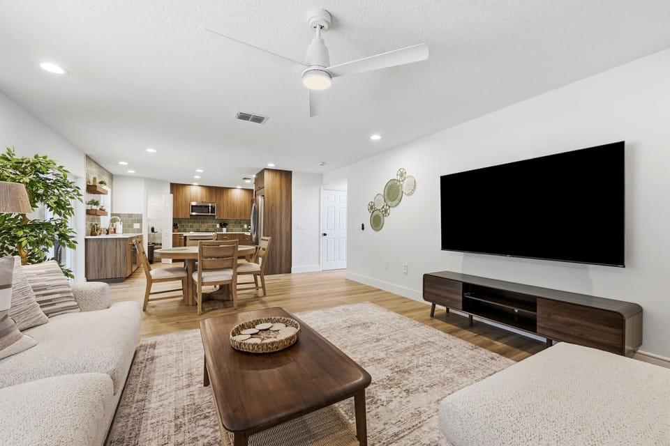 TV wall with the dining and kitchen spaces visible beyond.