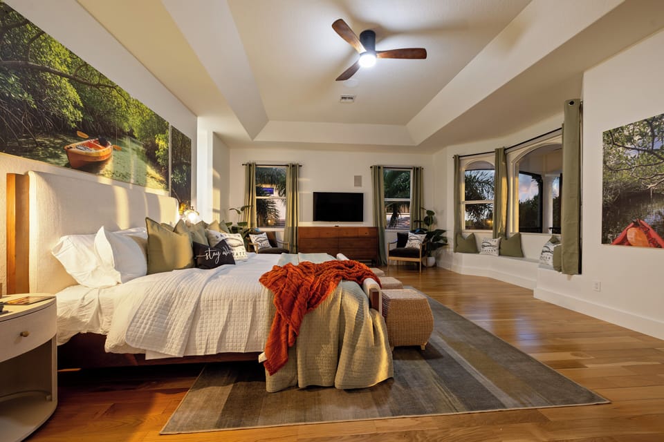 Relax in the spacious primary suite featuring a plush king bed, cozy seating are