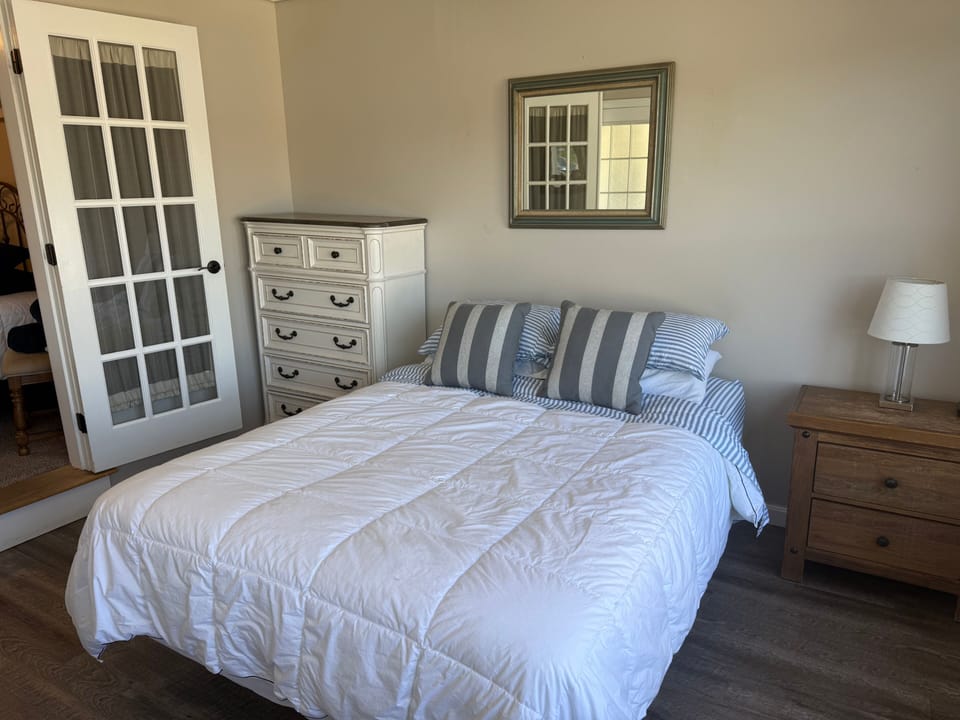 Cozy, light-filled bedroom with charming French doors and classic furnishings