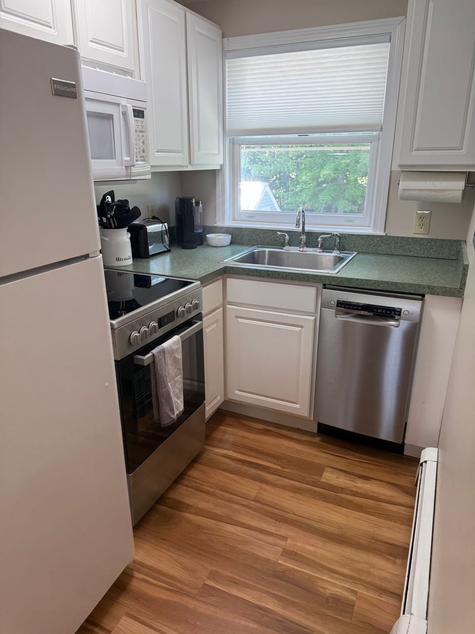 Bright kitchen with stainless appliances and sunny window views