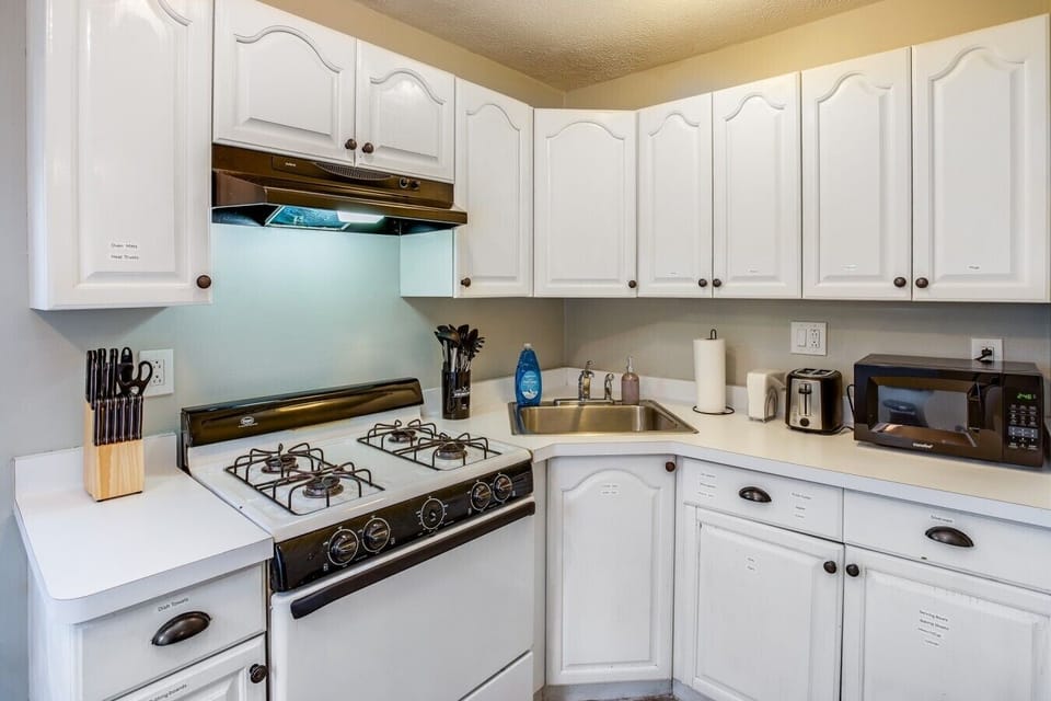 Modern kitchen with a gas stove, sink, and microwave—everything you need for easy meal prep.