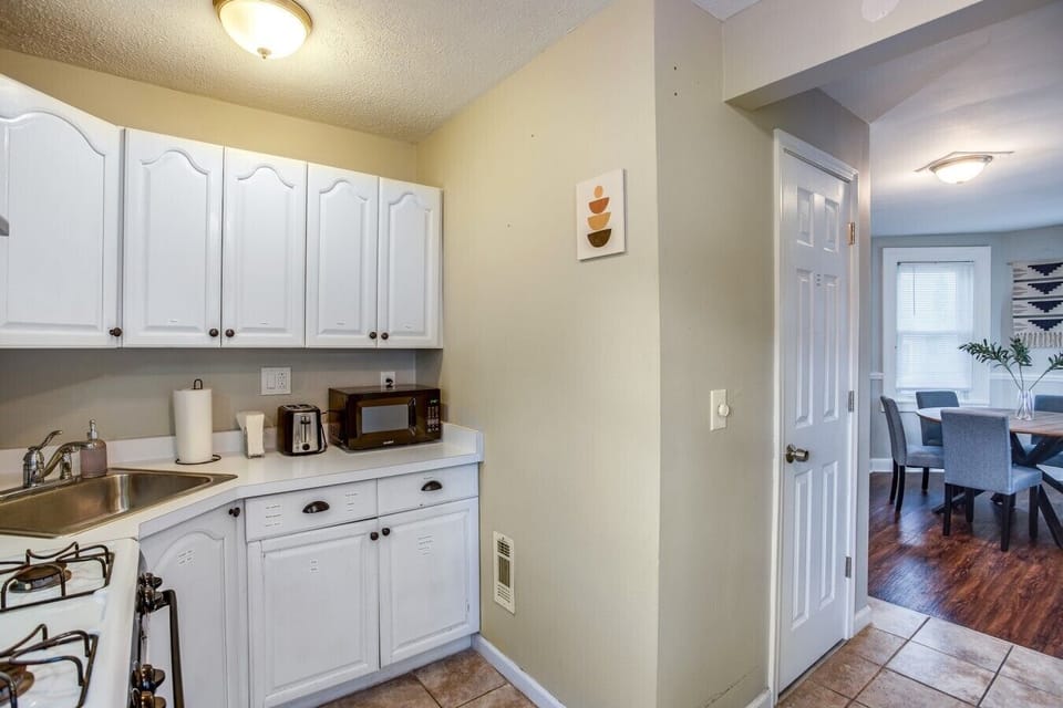 Modern kitchen with white cabinets and a cozy dining area.