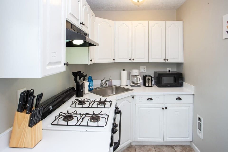 Compact kitchen with a gas stove, sink, and microwave for everyday convenience.