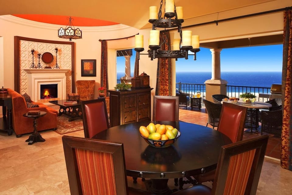Elegant dining space with fireplace and stunning ocean-view terrace