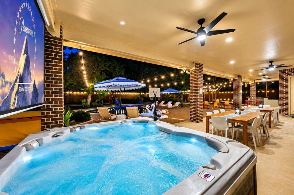 Resort-style backyard with hot tub, pool, and covered dining patio