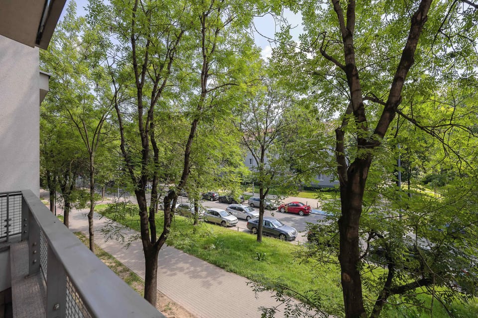 Balcony view surrounded by mature trees, creating a peaceful atmosphere.