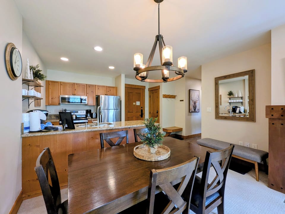 Gather around your dining table for meals with mountain-lodge charm. The open kitchen makes it easy to cook and connect, while warm wood tones and a statement chandelier create a cozy, welcoming vibe.