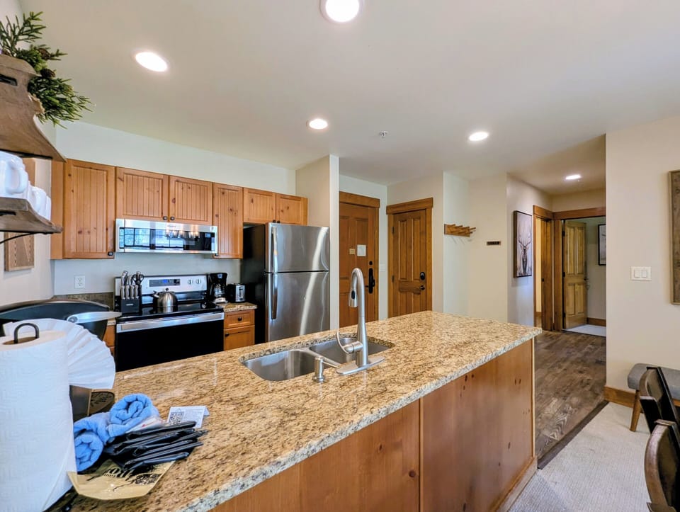 Your full kitchen features warm wood cabinetry, granite countertops, and stainless steel appliances—everything you need to prepare meals together during your mountain getaway.