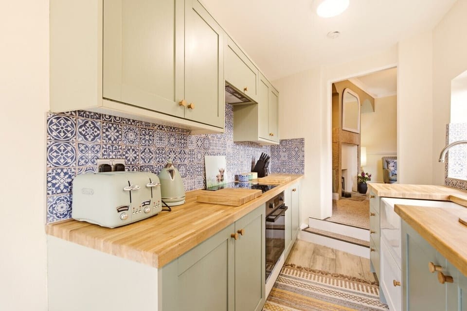 Galley kitchen with shaker cabinets and wood-effect worktops.