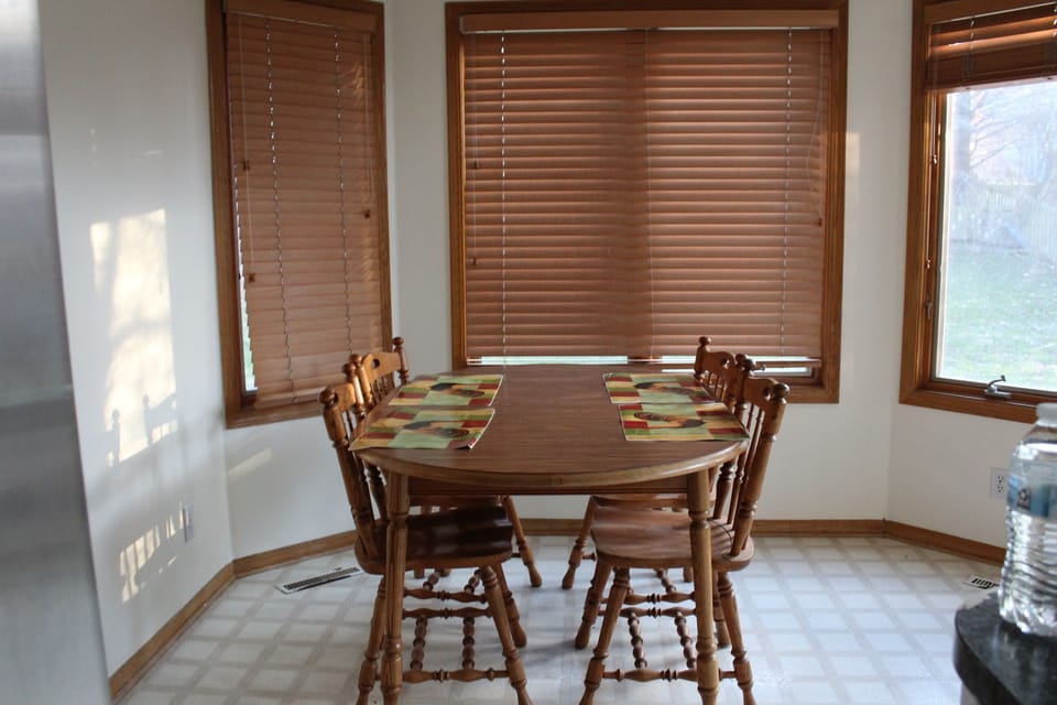 Bright breakfast nook with bay windows and seating for six.