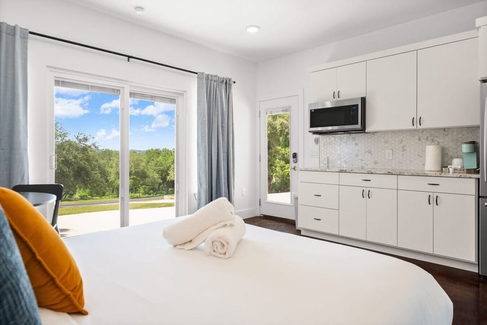 The studio kitchenette and sliding doors to green hill views make this a self-contained getaway.