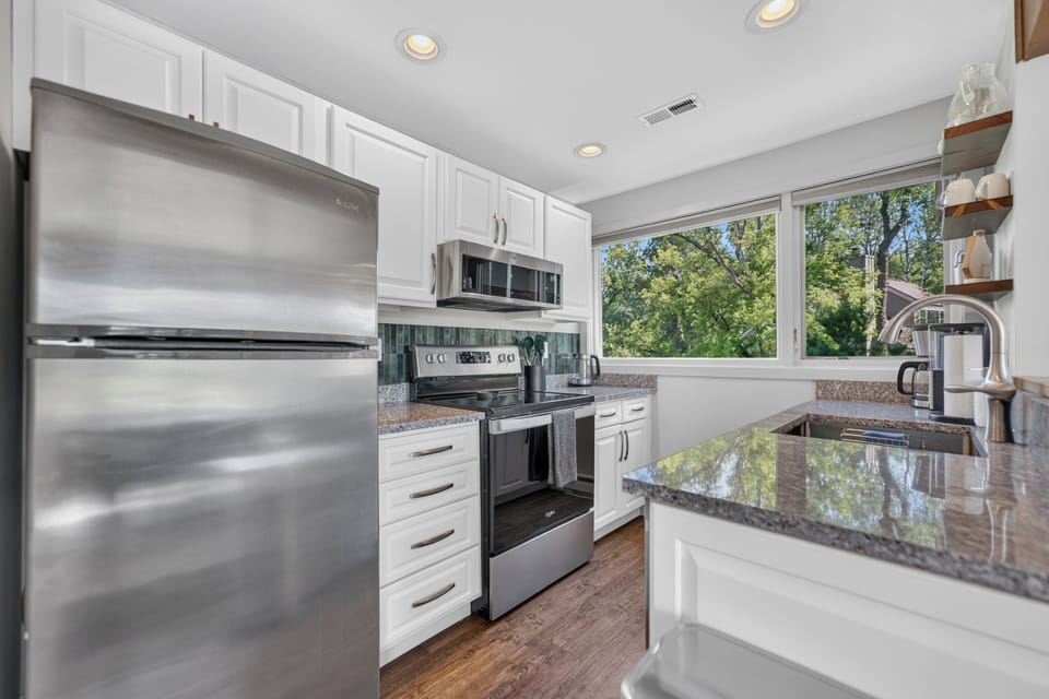 Fully equipped kitchen with stainless steel appliances, granite countertops, and everything needed for meals at home.