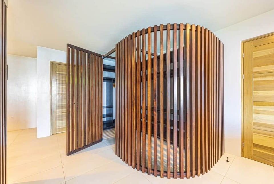 Sculptural wood-slat walk-in closet, connected to the bathroom. Where luxury meets functional art. 