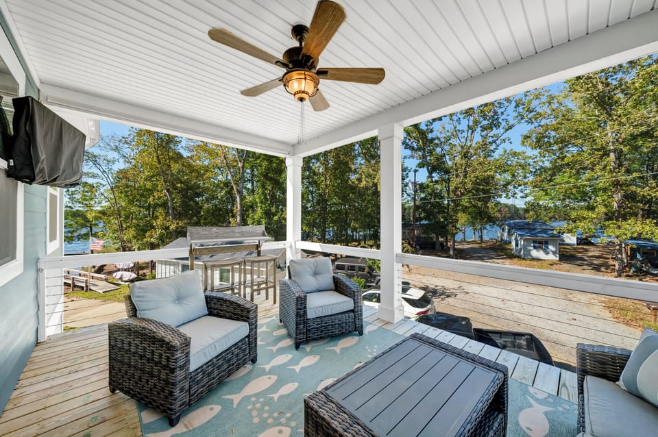 Covered upstairs deck with fan and television. 