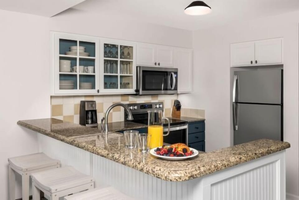 Bright modern kitchen with granite breakfast bar and stainless appliances
