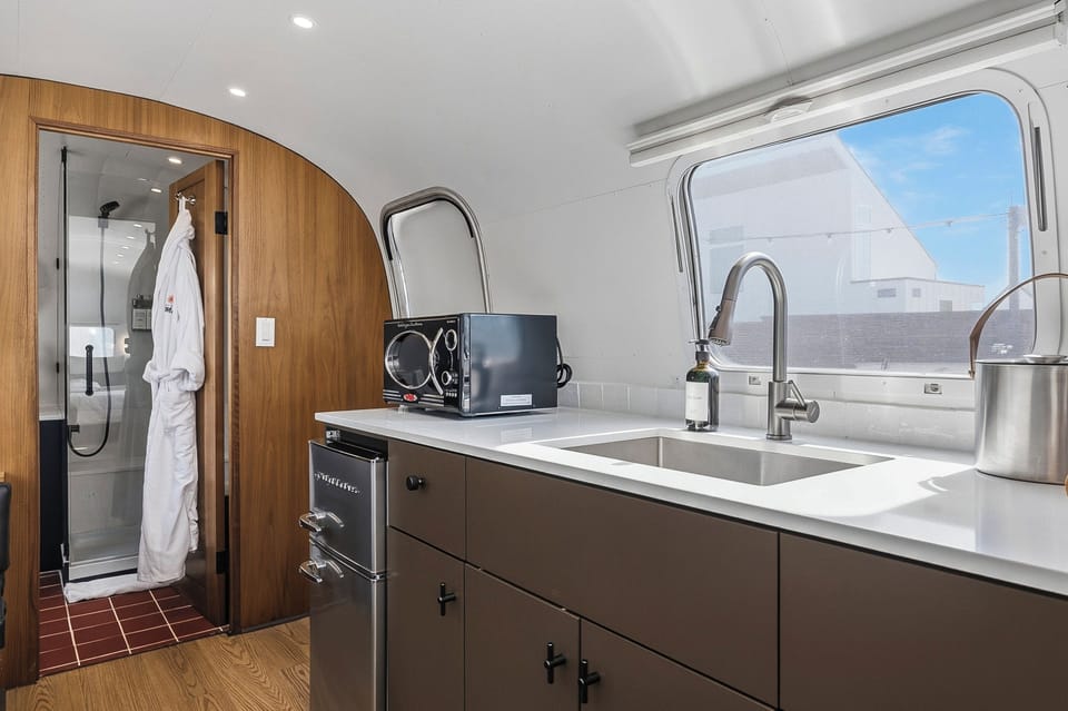 A sleek kitchenette with a fridge, prep space, and the essentials for easy mornings and simple nights in. Perfect for coffee, snacks, and reheating leftovers after a day out.