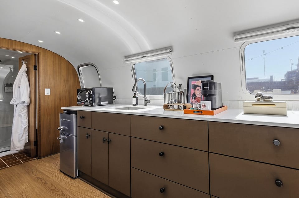 A sleek kitchenette with a fridge, prep space, and the essentials for easy mornings and simple nights in. Perfect for coffee, snacks, and reheating leftovers after a day out.