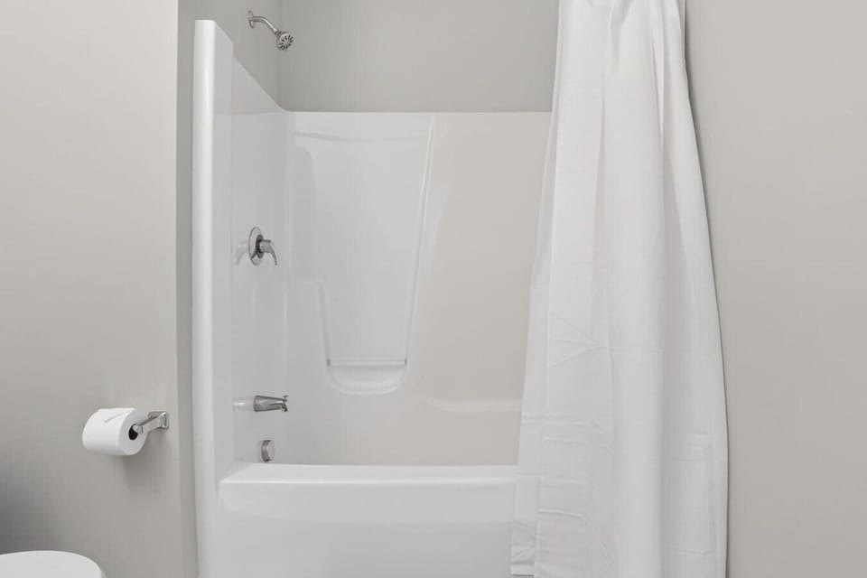 Tub and shower combination in the full bathroom.