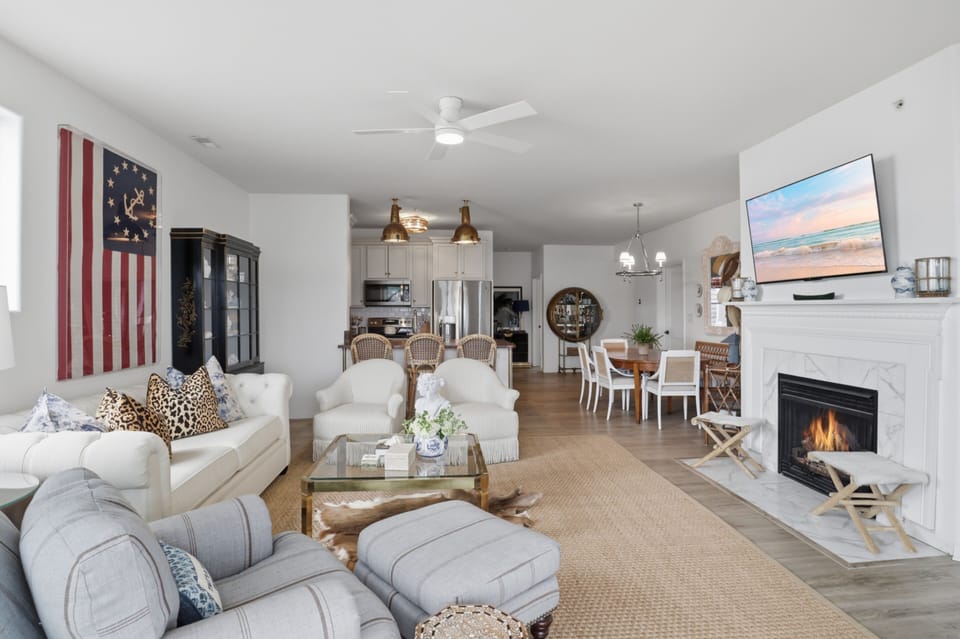 Open living area with fireplace, TV, dining space, and full kitchen