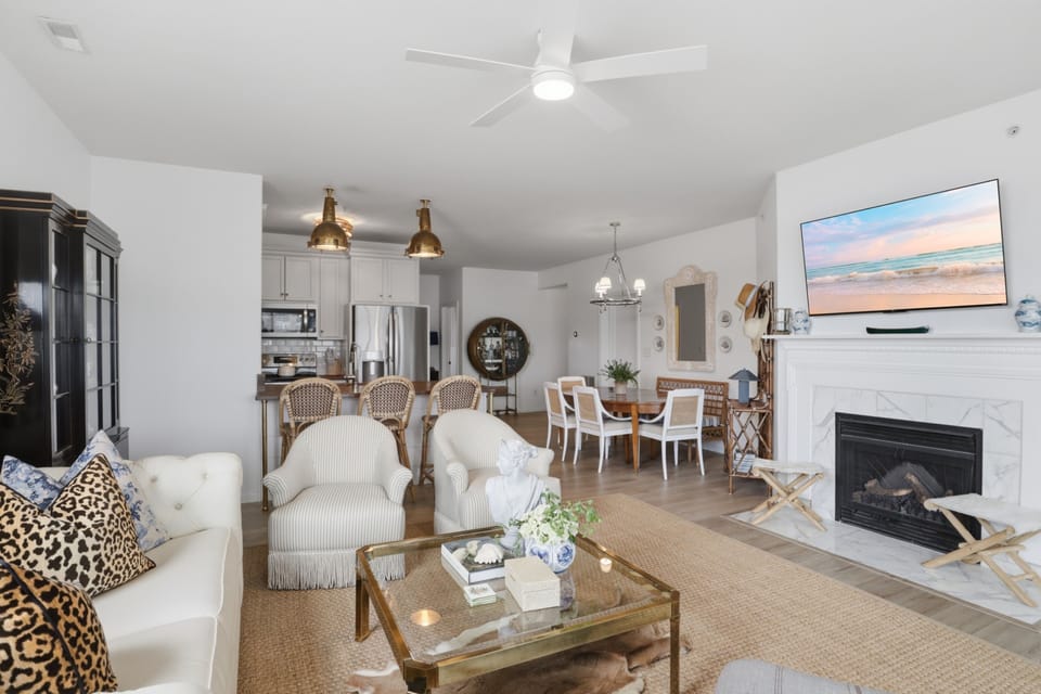 Open-concept living with fireplace, TV, and stylish coastal charm