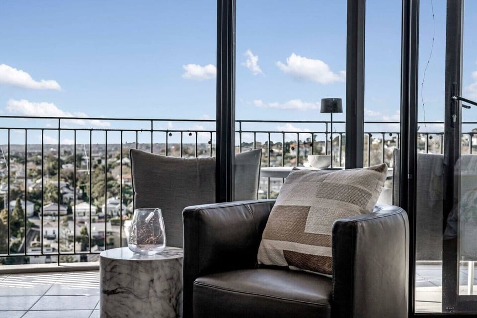 Living room with floor to ceiling doors and windows and views over Auckland