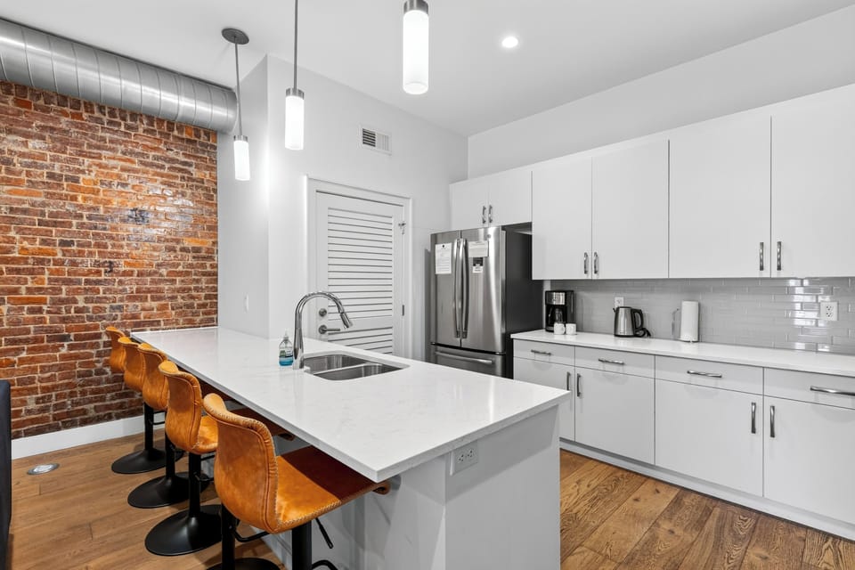 Clean, fully equipped modern kitchen with stainless steel appliances, gas range, and white cabinetry.