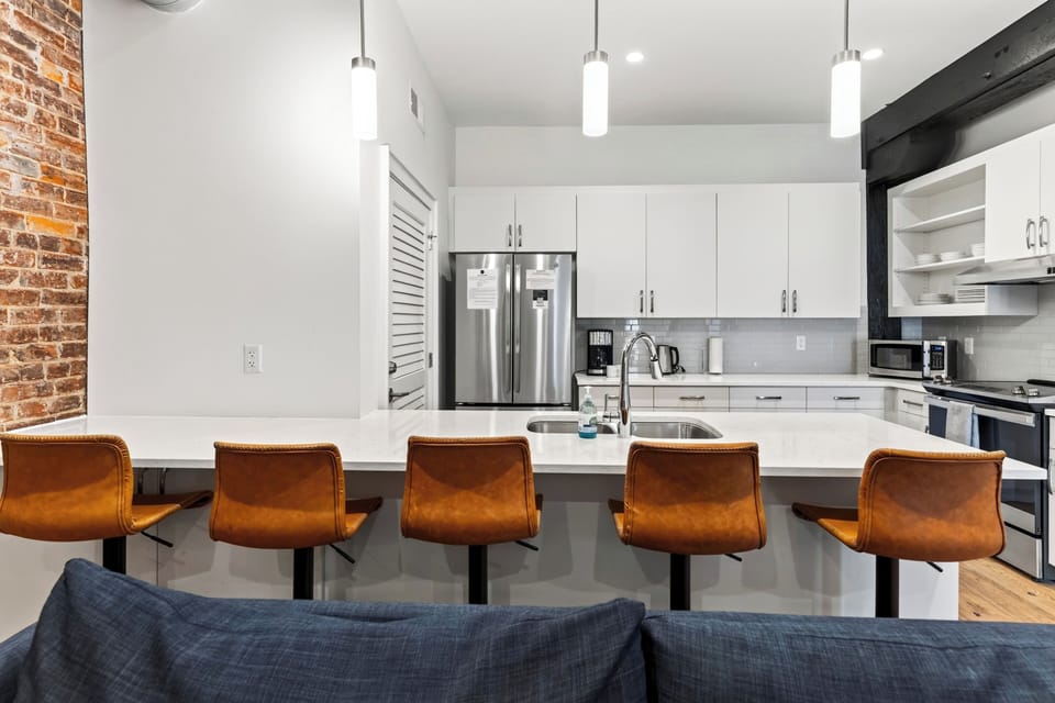 Kitchen island bar counter with high-top barstools overlooking the living space.