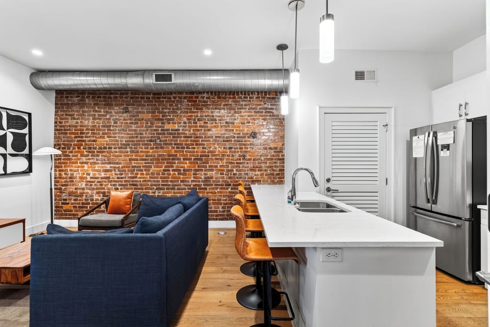 Kitchen island bar counter with high-top barstools overlooking the living space.