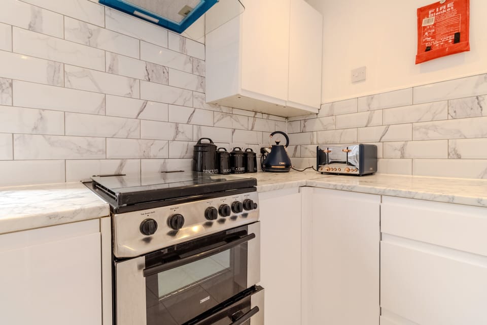 Modern kitchen with marble finishes, oven, kettle, and toaster