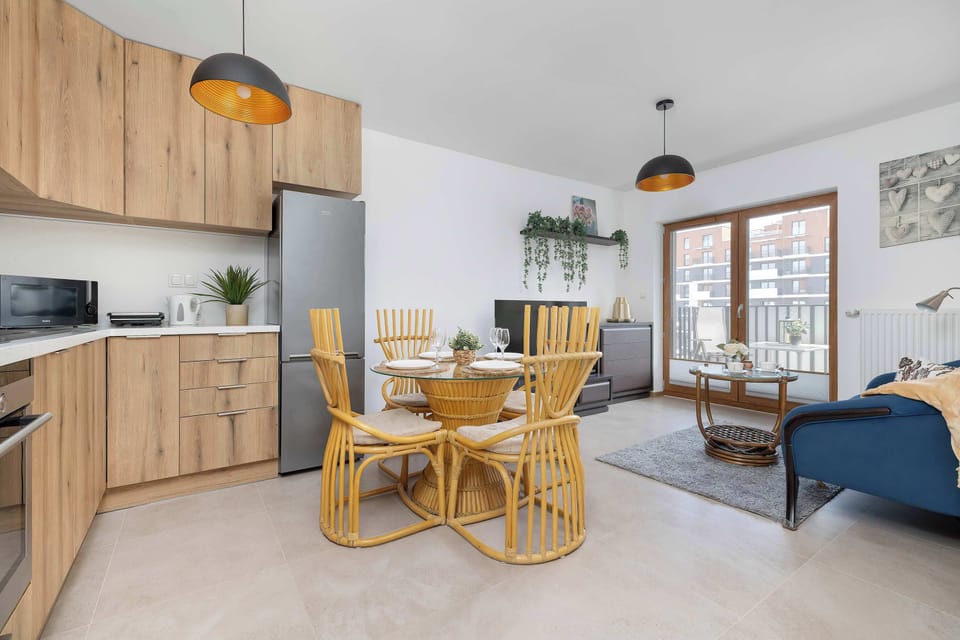 An open-plan space with a kitchenette, dining area, and living room. Large windows make the interior bright and welcoming.
