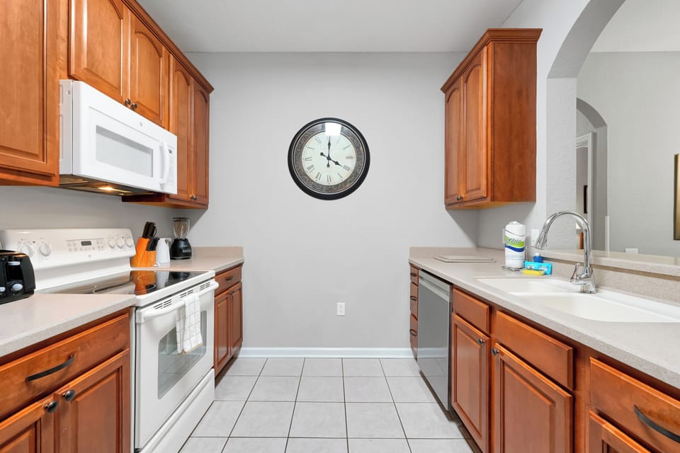 Your fully equipped kitchen features warm wood cabinetry, ample counter space, and modern appliances—perfect for preparing family meals or morning coffee during your stay.
