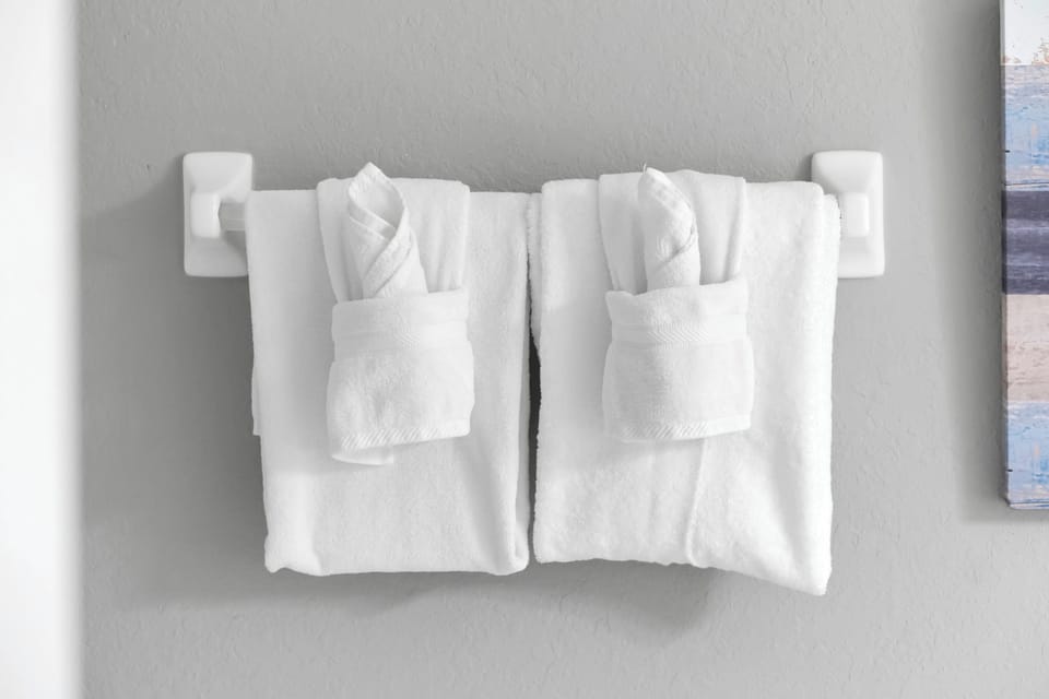 Fresh, fluffy towels await you, neatly arranged and ready to wrap you in comfort after your shower.