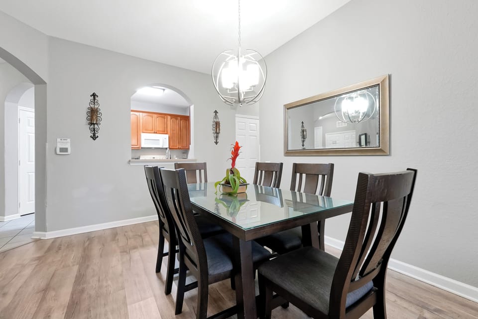 Gather around the elegant dining table beneath a sculptural pendant light, where memorable meals and conversation await. The open flow to the kitchen makes hosting effortless.