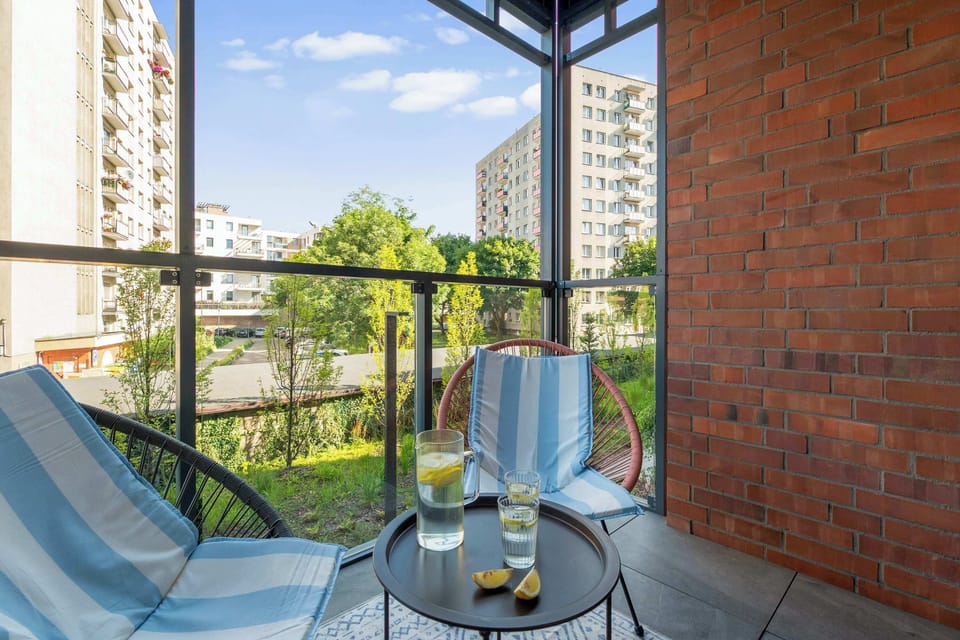 Z części dziennej można wyjść na umeblowany balkon wyposażony w dwa fotele i niewielki stolik. To przyjemne miejsce na poranną kawę lub odpoczynek na świeżym powietrzu. Z balkonu rozpościera się widok na sąsiednią zabudowę.