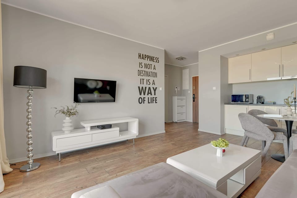 W strefie wypoczynkowej znajduje się wygodna narożna sofa, która może pełnić funkcję dodatkowego miejsca do spania, stolik kawowy oraz telewizor z funkcją Smart TV.