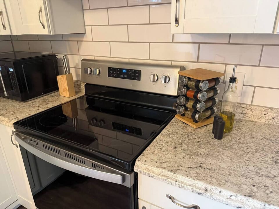 Prepare meals with ease in the fully equipped kitchen, featuring modern appliances, ample counter space, and essential cooking supplies.
