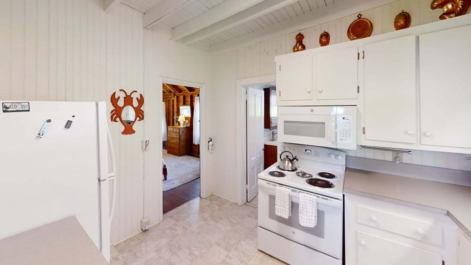 Kitchen area with view of first floor bedroom 1 and full bathroom with tub/ shower combo.