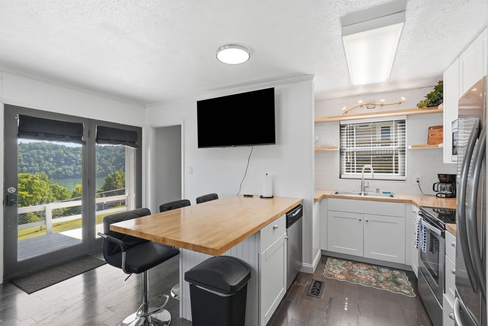 Bright kitchen with island seating and scenic water-view balcony access