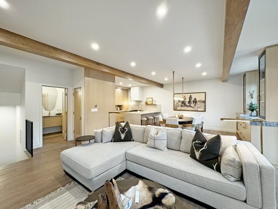 A glimpse of the powder room and staircase, seamlessly joining this warm living area. Sink into the comfortable couch and feel right at home.