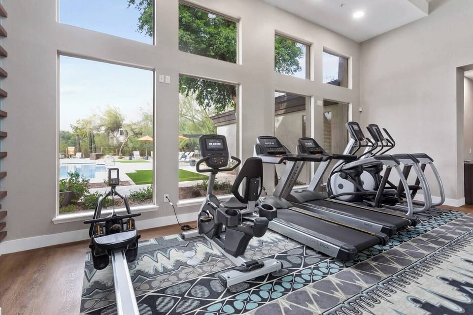 Bright fitness room with pool views and modern cardio equipment