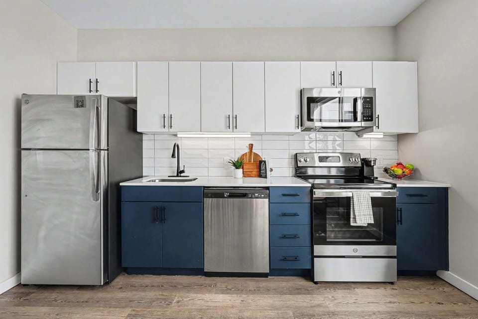 Make yourself at home in this sleek modern kitchen, featuring full-size stainless-steel appliances, generous storage, and stylish navy-and-white finishes.