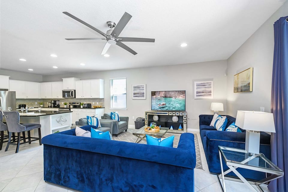 The open-plan family room offers comfortable seating, a large Smart TV, and direct access to the pool deck. It's the perfect gathering space for movie nights, relaxing after the parks, or spending quality time together.