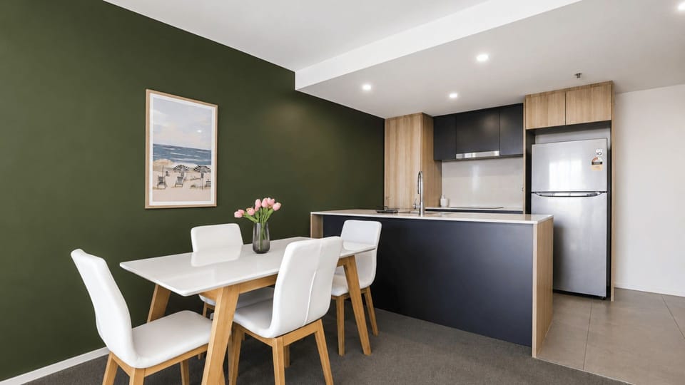 Dining space set for four beside the fully equipped kitchen.