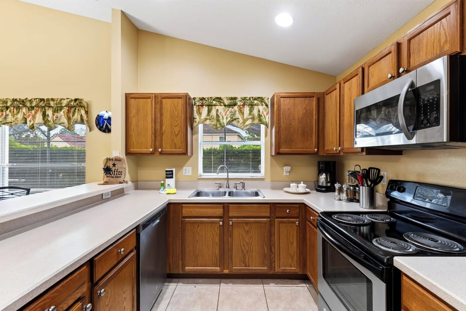 Full view of the kitchen complete with ample cabinetry, stainless steel appliances, and a double sink.