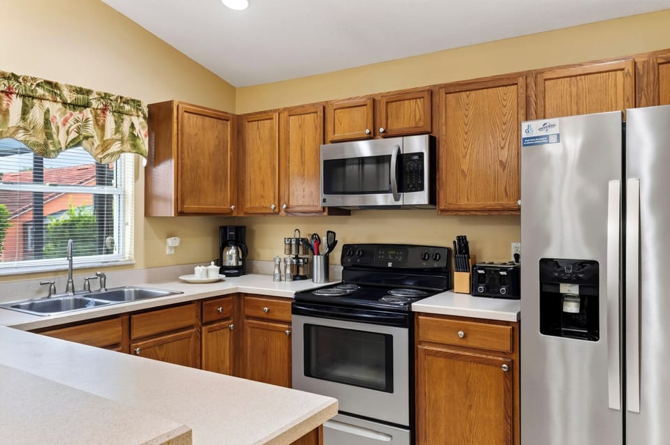 Kitchen angle showing modern appliances, microwave oven, and clean countertop workspace.